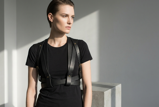 Black leather chest harness over a t-shirt